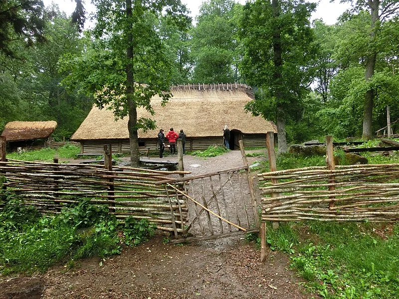 Rekonstruerade långhus och historiska miljöer i lummig grönska vid Ekehagens forntidsby utanför Skara.