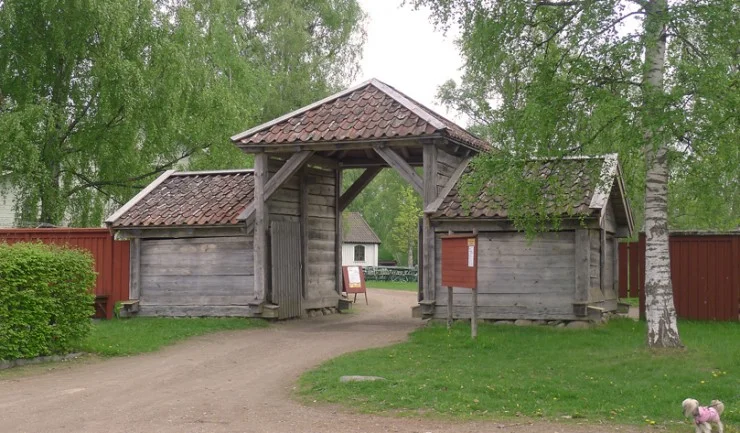 Gammal timrad bebyggelse och historiska gårdsmiljöer vid friluftsmuseet Fornbyn i Skara.