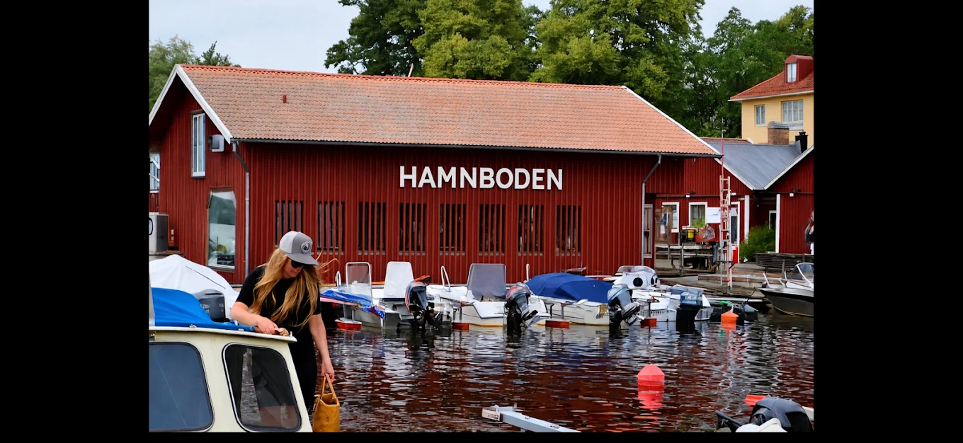 Hamnboden aan het Vättermeer in Hjo met verkoop van gerookte trekzalm en lokale lekkernijen in de idyllische havenomgeving.