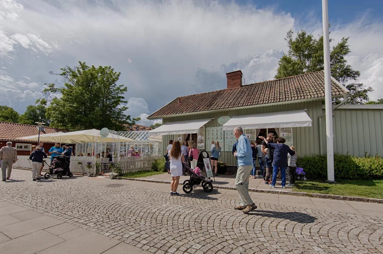 Sommargäster som njuter av glass och fika vid Moster Elins café på Hjo Brygga vid Vättern.