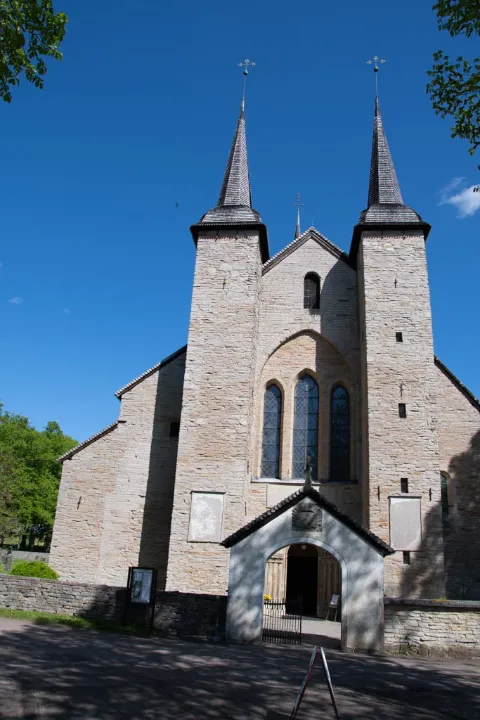 Exteriör av den historiska Varnhems klosterkyrka i Skara med sina karaktäristiska spiror och medeltida arkitektur.
